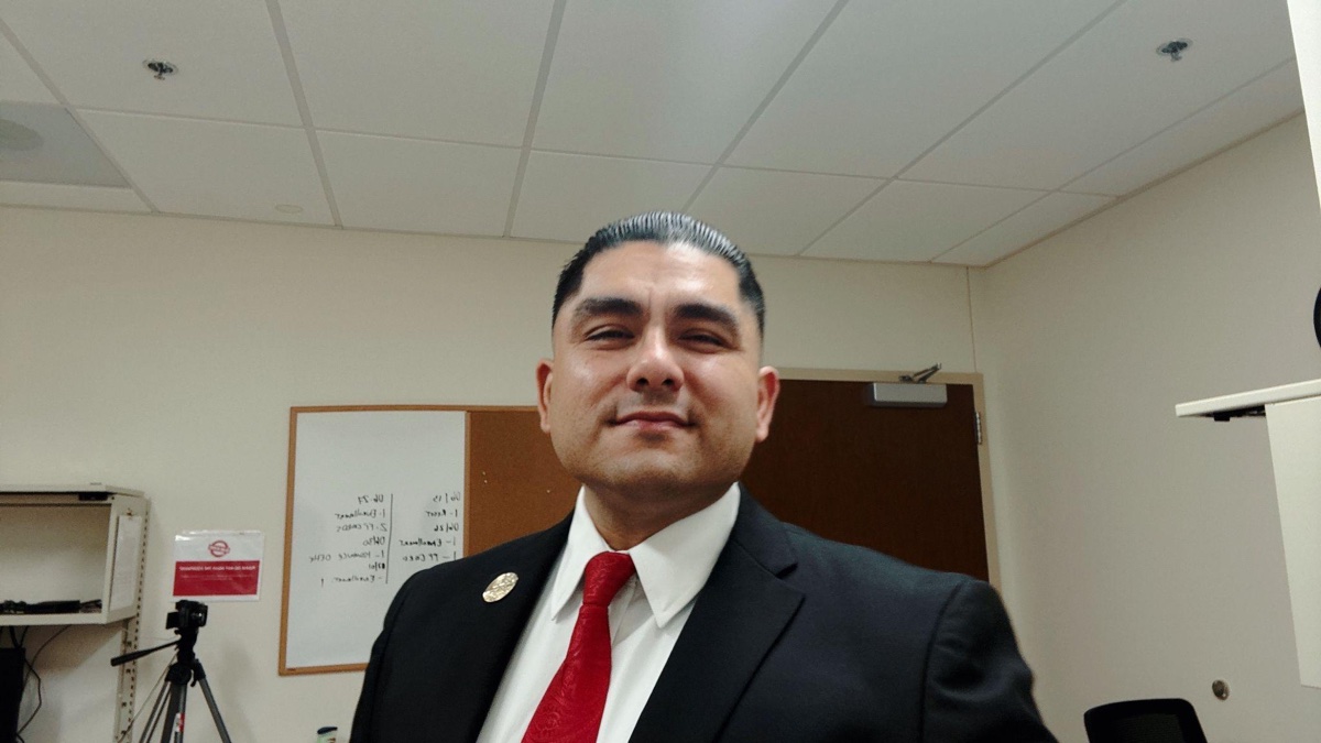 Cody Hartt wearing a dark suit and red tie.