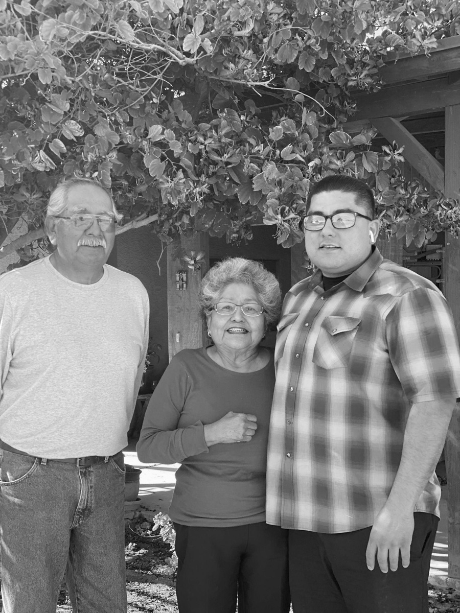 Black-and-white photograph of three family members standing together outdoors.