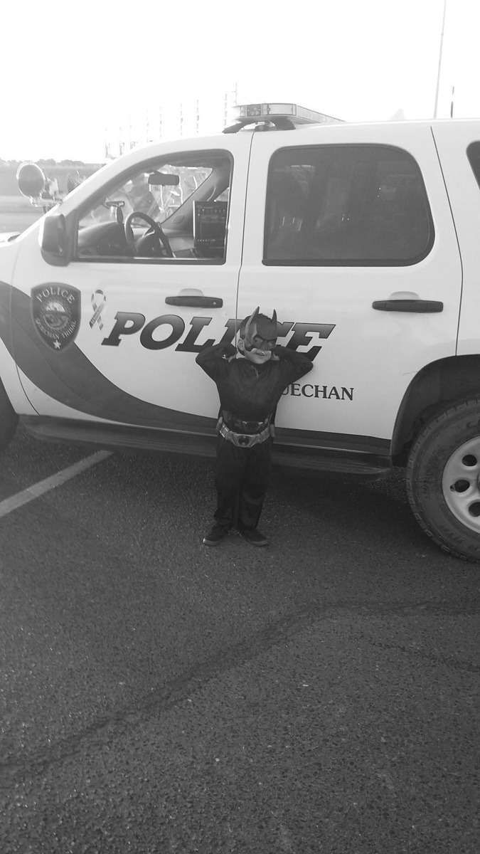 A child standing beside a Quechan Police vehicle.