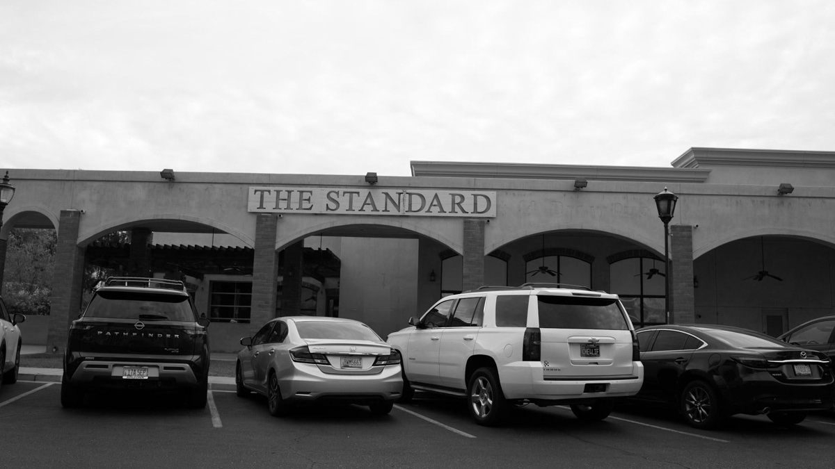 The Standard building with vehicles parked outside.